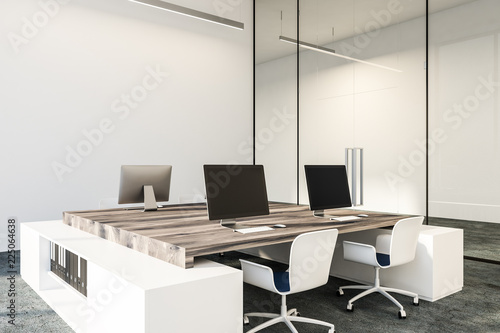 Black computer screens on wooden office desks