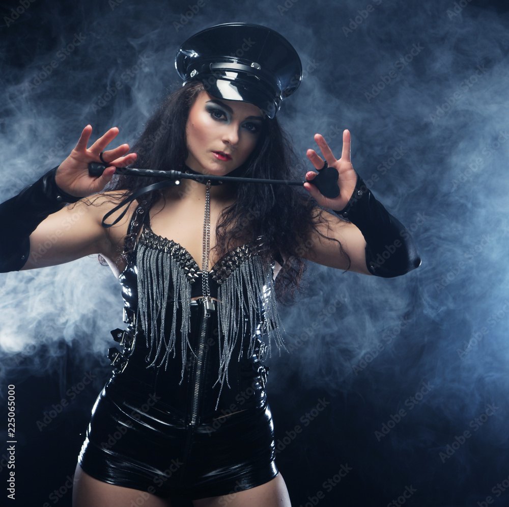 Sexy brunette woman mistress holding whip,over dark backgrouynd with smoke  Stock Photo | Adobe Stock