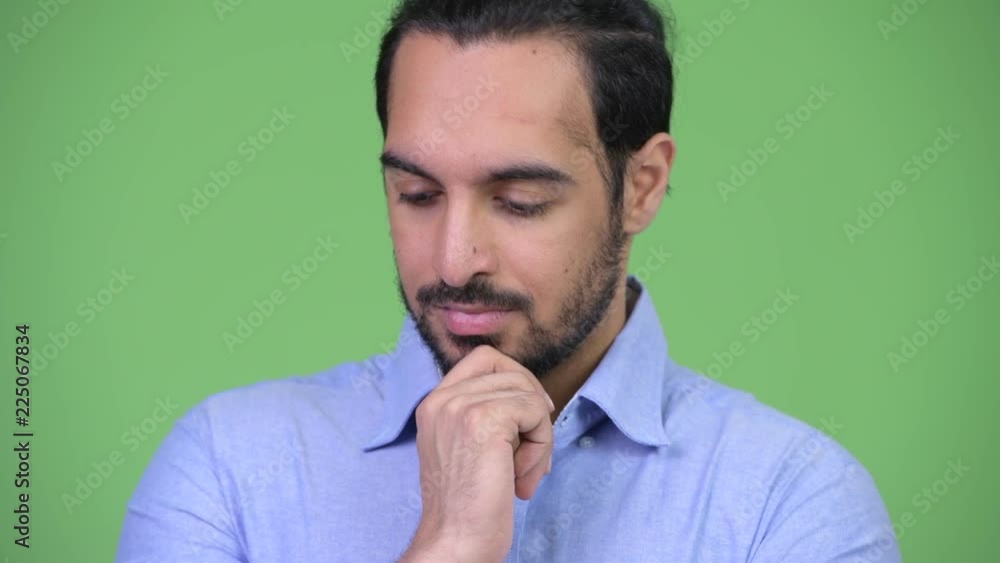 Young serious bearded Indian businessman thinking Young serious bearded Indian businessman thinking