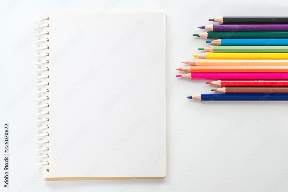 notepad with color pencil on white table view from above notepad with color pencil on white table view from above