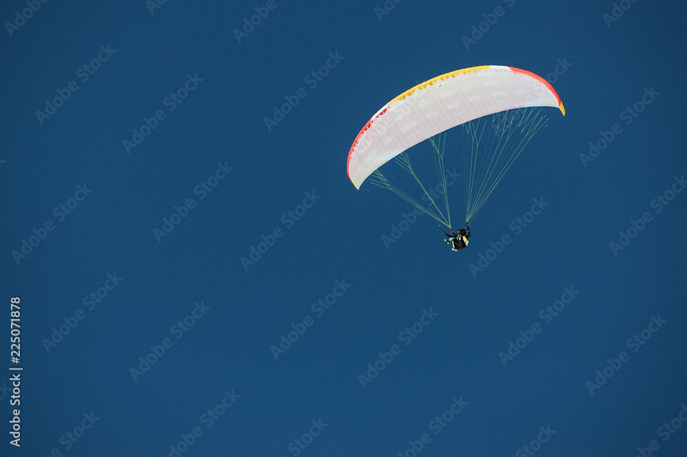 Skydiver under a canopy of a parachute against a blue sky in Georgia, Gudauri Skydiver under a canopy of a parachute against a blue sky in Georgia, Gudauri