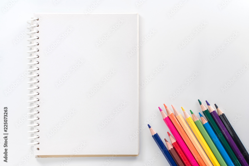 notepad with color pencil on white table view from above notepad with color pencil on white table view from above
