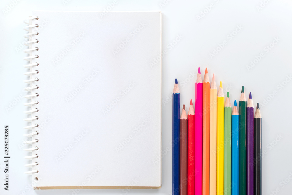 notepad with color pencil on white table view from above notepad with color pencil on white table view from above