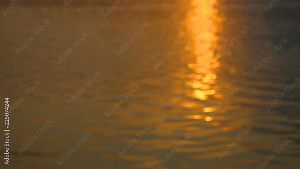 Slow motion video of defocus water surface with out of focus bokeh of sun glares in twilight time (Blur background Video) Slow motion video of defocus water surface with out of focus bokeh of sun glares in twilight time (Blur background Video)