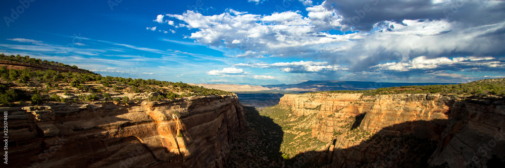 Panorama of sunset light on the steep stone cliffs of Monument Canyon in Colorado National Monument