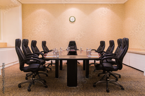 Conference room for business meetings large table in the middle of the room around comfortable chairs on the wall hang the clock