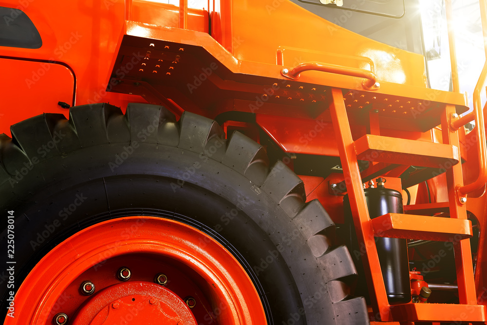 Details of modern red tractor close up, bottom view, black tires Details of modern red tractor close up, bottom view, black tires