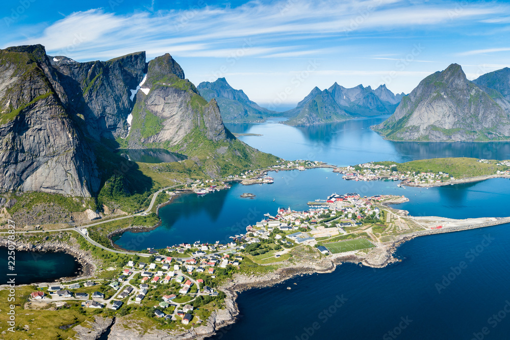 Reine Lofoten Norway, aerial view of Norwegian traditional fishing village above polar circle with blue sea and mountains during sunny arctic summer, famous for Reinebringen hike - obrazy, fototapety, plakaty 