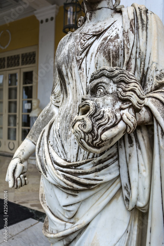 Canvas-taulu A tragic mask in the hand of Statue of Melpomene, the muse of tragedy, on the balcony of Achillion palace on greek island Corfu in Greece