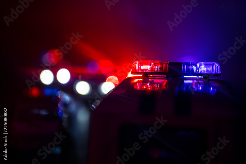 Police car chasing a car at night with fog background Fototapeta