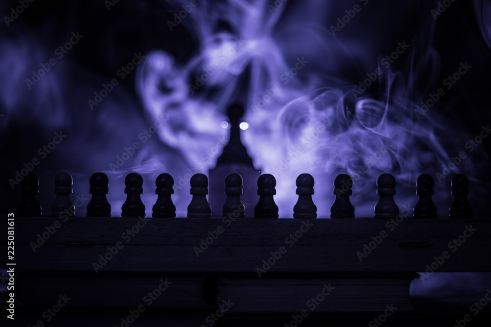 Obraz premium Chess board game concept of business ideas and competition or strategy ideas concept. Chess figures on a dark toned foggy background.