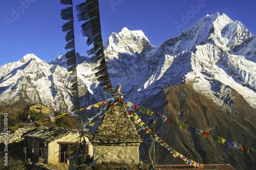 Yeti Lodge Nepal Stone Building Shelter with Buddhist Prayer Flags and Distant Snowy Himalayan Mountain Peaks