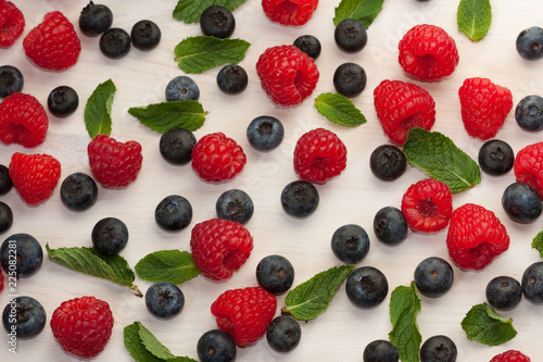 Background with fresh raspberries, blueberries and mint.