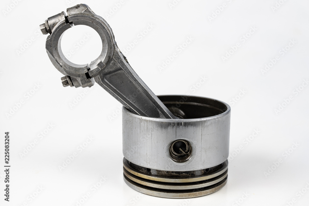 A small combustion engine piston on a white table. Spare parts for mechanics. A small combustion engine piston on a white table. Spare parts for mechanics.