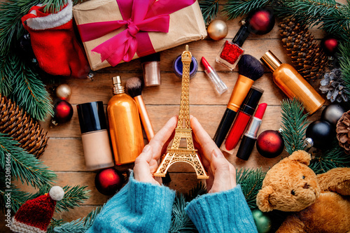hands holding Eiffel tower on background with cosmetics photo
