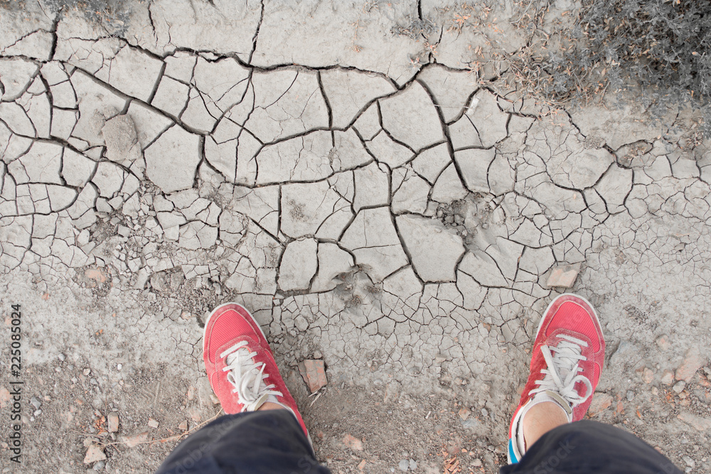 Fototapeta premium man standing on dry cracked soil