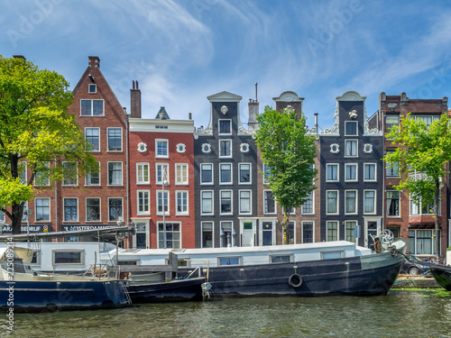 Buildings and boats along Amsterdam's beautiful  canals in central Amsterdam during the day. The canals are one of Amsterdam's main attractions.