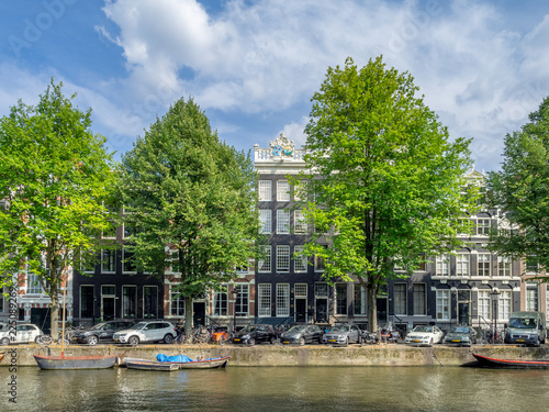 Buildings and boats along Amsterdam's beautiful  canals in central Amsterdam during the day. The canals are one of Amsterdam's main attractions.