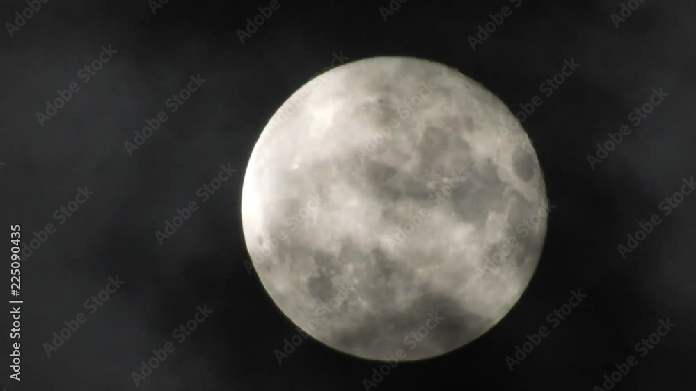 Full Moon in a cloudy night sky with clouds moving around. Close up  4k video