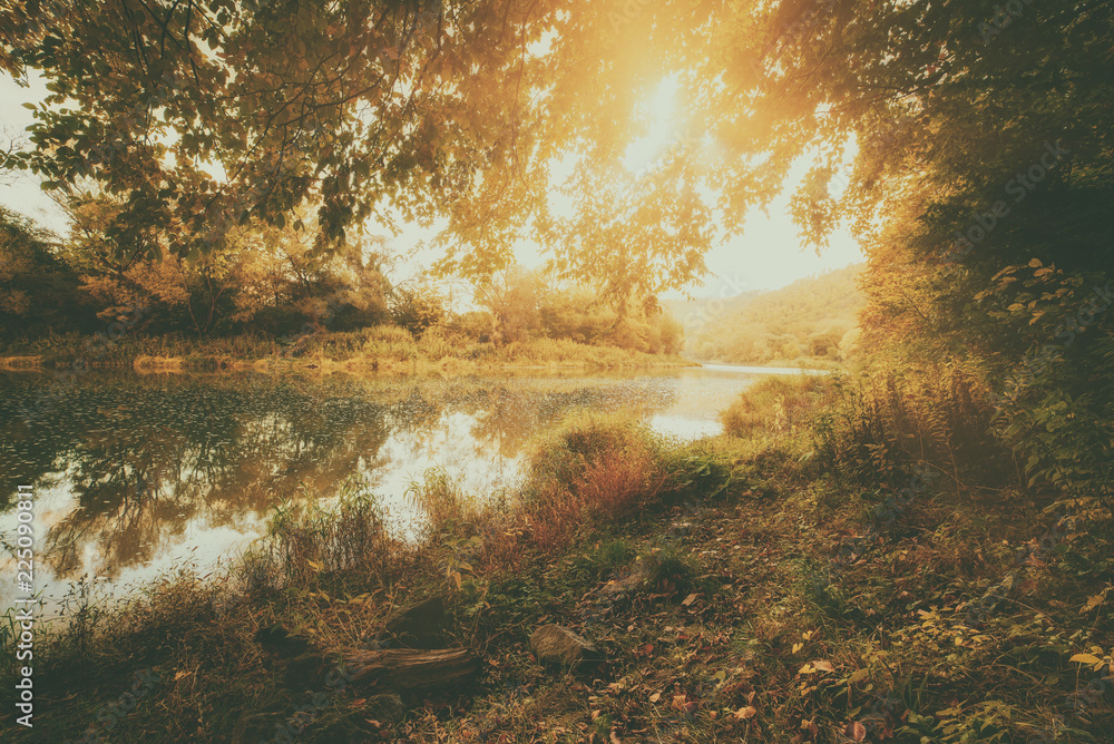 Beautiful sunny autumn landscape with reflection in the water and sun shine Beautiful sunny autumn landscape with reflection in the water and sun shine