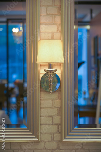 Decorating wall lamp with classic style lamp shade on brick wall doorway.