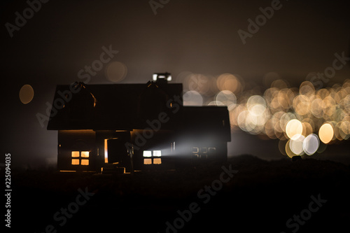 Little decorative house, beautiful festive still life, cute small house at night, Night city real bokeh background, happy winter holidays