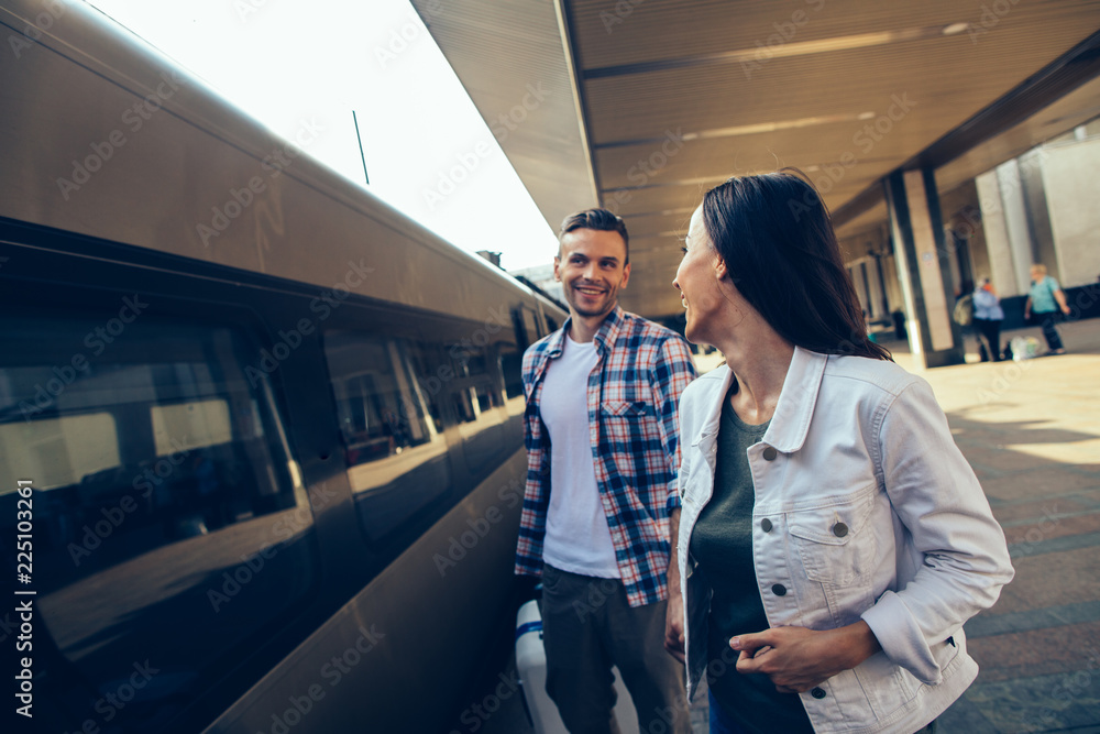 Happy woman talking with outgoing bearded guy before journey outside. Glad couple during communication before trip concept Happy woman talking with outgoing bearded guy before journey outside. Glad couple during communication before trip concept