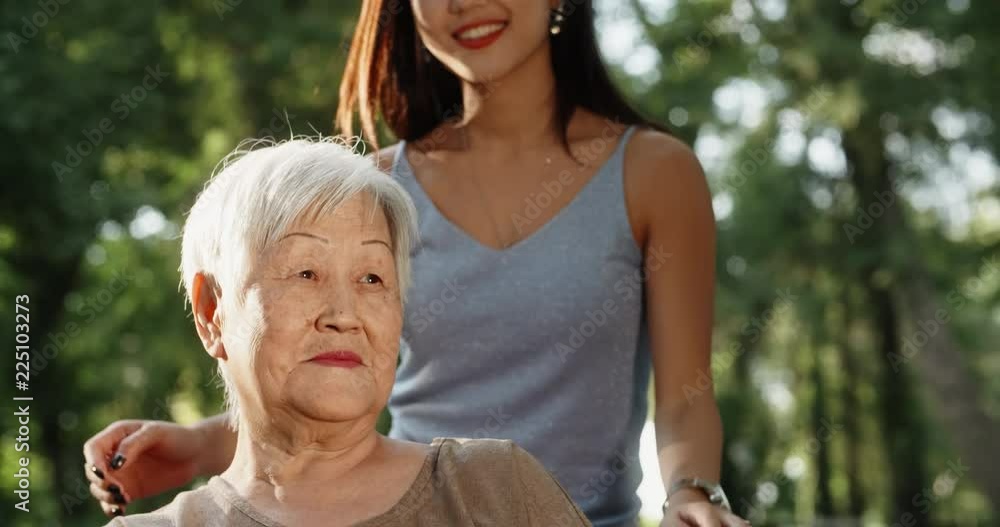 Teen asian granddaughter hugging and kissing her happy mature