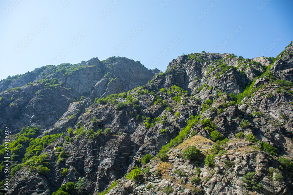 Majestic landscape of the mountains and forest in Caucasus at summer. Dramatic sky with clouds.