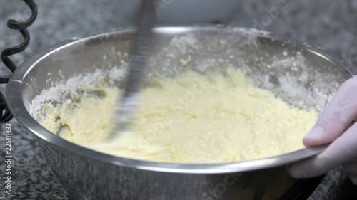 Swiftly stirring dough and flour. Quickly moving utensil mixing up thick dough and flour. photo