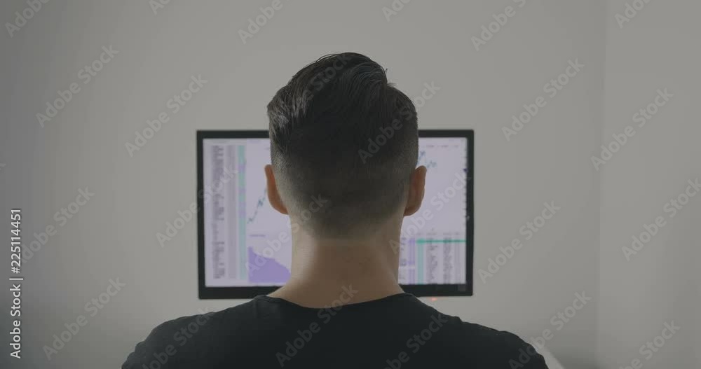 Back view of Stockbroker is working with financial market Back view of Stockbroker is working with financial market