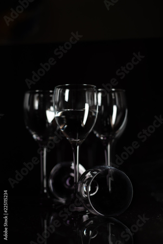 Four champagne glasses on a black background.