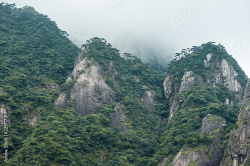 forest covered mountain peaks covered in heavy cloud at Mount Sanqing geo park 