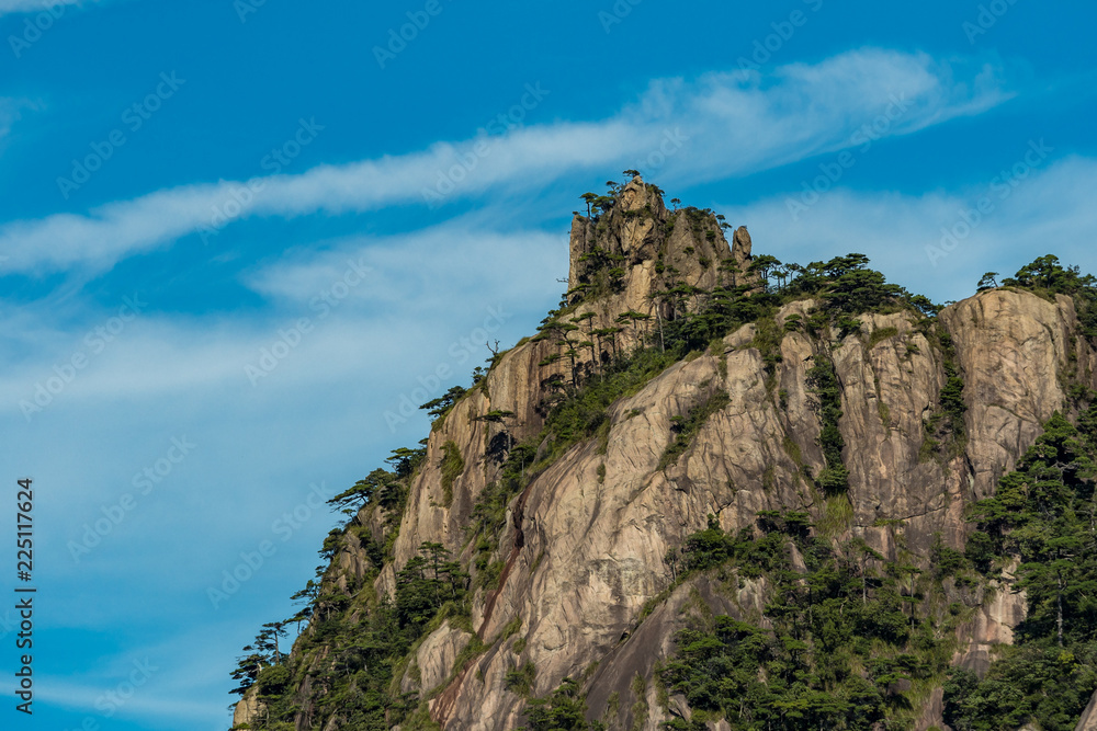 unique peaks covered with green forest under the blue cloudy sky at mount Sanqing geo Park