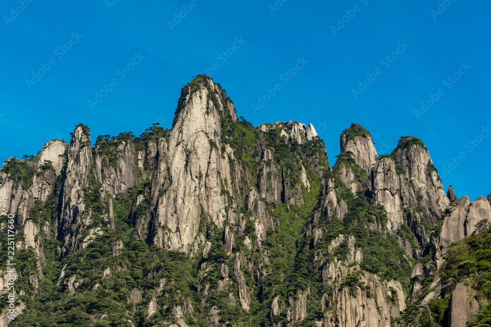 unique peaks covered with green forest under the blue sky at mount Sanqing geo Park