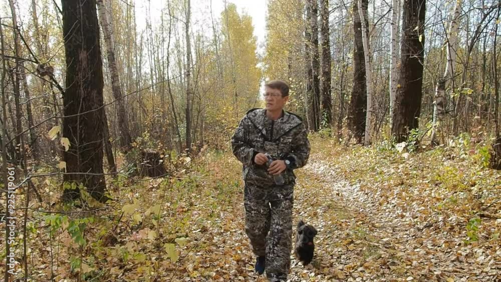 A man in the woods walking with a dog. A man in the woods walking with a dog.