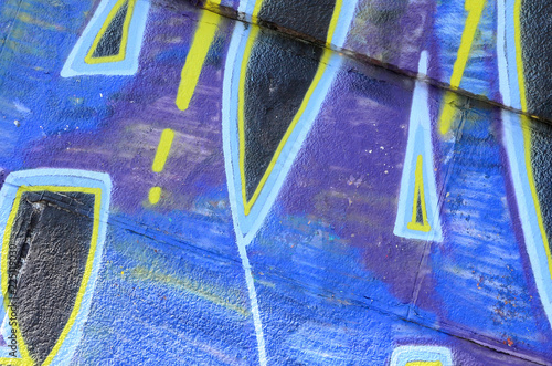 Fragment of graffiti drawings. The old wall decorated with paint stains in the style of street art culture. Colored background texture in cold tones