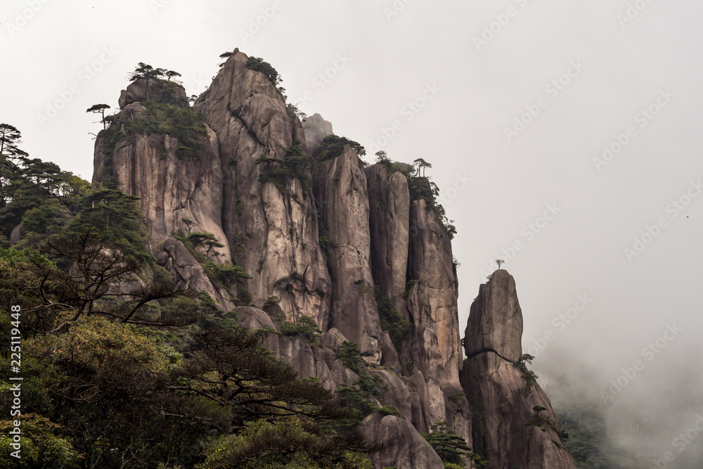 hand shaped rock formation on the mountain slop covered by forest under the mist hand shaped rock formation on the mountain slop covered by forest under the mist
