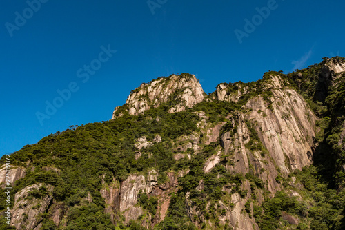 unique peaks of Mt. SanQiang covered in green under cloudy blue sky