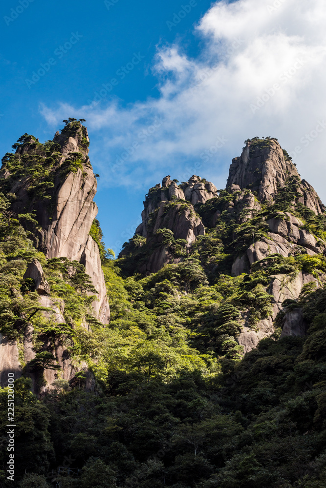 unique peaks of Mt. SanQiang covered in green under cloudy blue sky unique peaks of Mt. SanQiang covered in green under cloudy blue sky