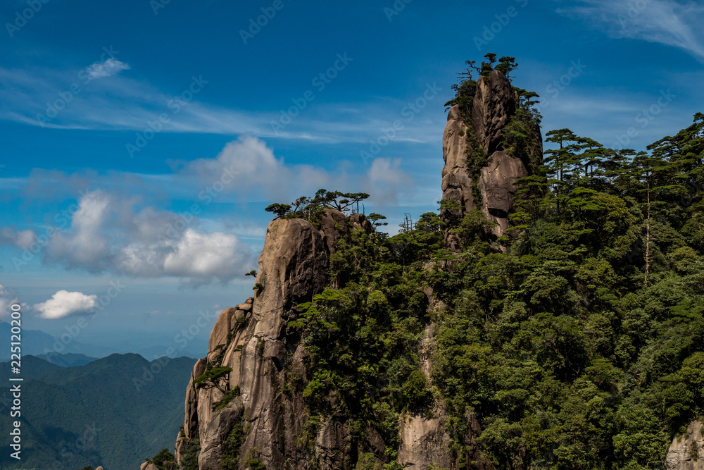 unique peaks of Mt. SanQiang covered in green under cloudy blue sky