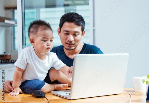 Man father working on laptop computer