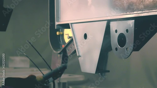 Man cleans metal surface by sandblaster gun in a metal construction factory. Shotblaster in a process