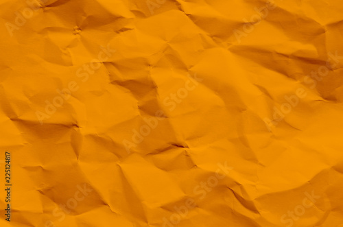 Orange background and wallpaper by crumpled paper texture and free space.
