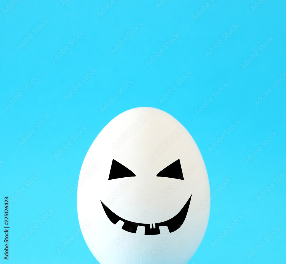 minimal and funny Halloween holiday concept. white egg with scary cute face. minimal and funny Halloween holiday concept. white egg with scary cute face.