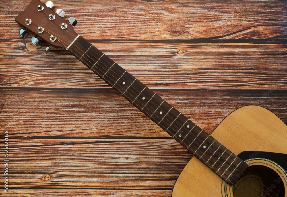 Fototapeta premium Acoustic guitar on wooden background. Music and melody concept.