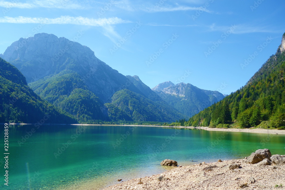 Lago del Predil (Predil Lake), small mountain lake with turquoise water in Julian Alps, Tarvisio with mountains in background, Italy