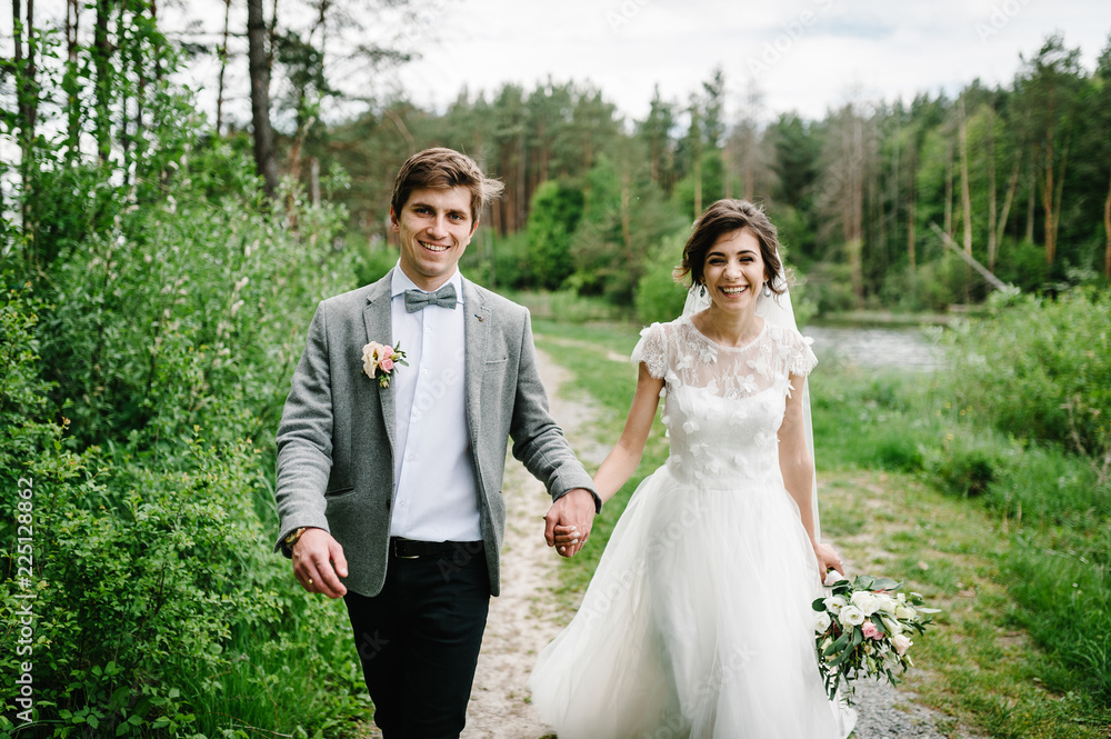 Happy bride and groom getting married in the green forest. Wedding ceremony.