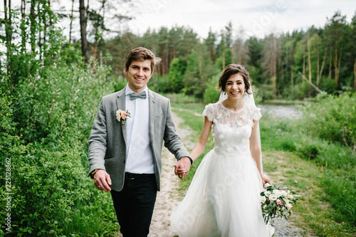 Happy bride and groom getting married in the green forest. Wedding ceremony.