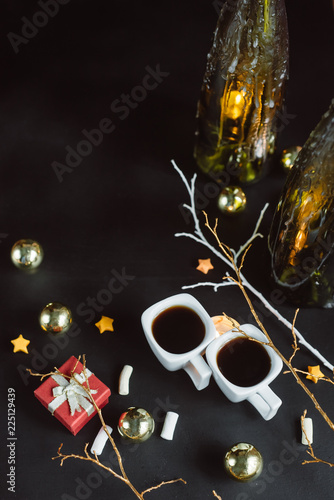 Winter composition. Two cups of coffee, branches, candles and Christmas toys on a dark background. Flat lay